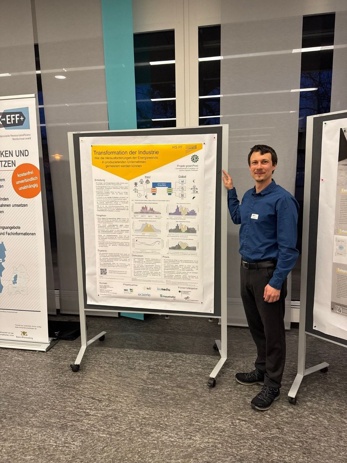 INEC-Mitarbeiter Felix Bischoff neben dem greenProd-Poster